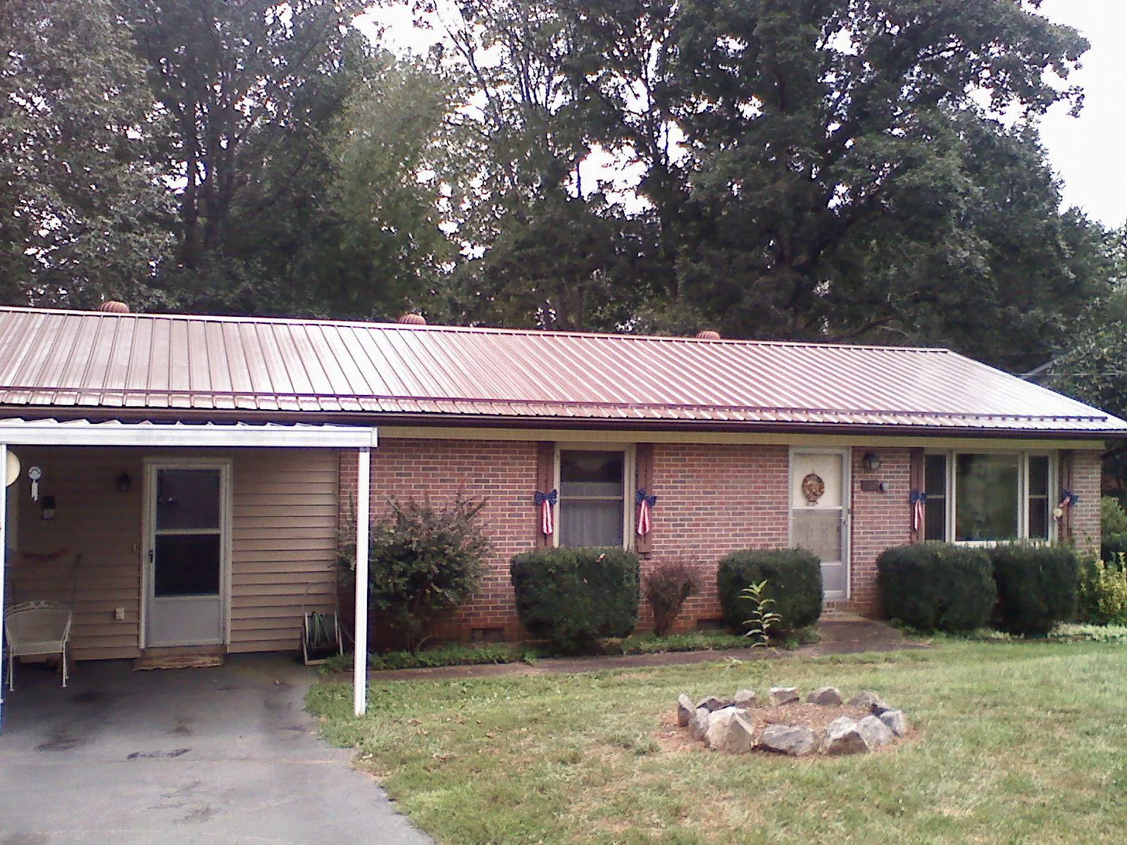 Bronze metal roof and carport on a brick ranch home — Roof Repair work by our crew in Unadilla